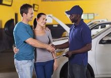 Photo of couple with man shaking hands with mechanic
